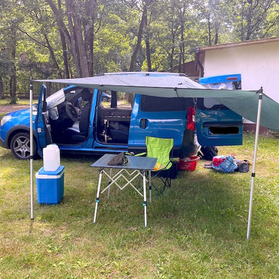 A mini camper with awning.