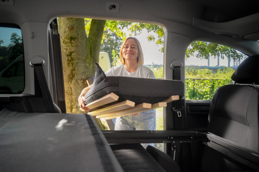 Moodbild: Anna lädt gerade ein Matratzenteil in ein Auto.