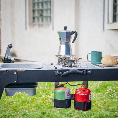 Moodbild: Campingküche draußen im Einsatz zum Frühstück, Saft, Brötchen und Kaffee.